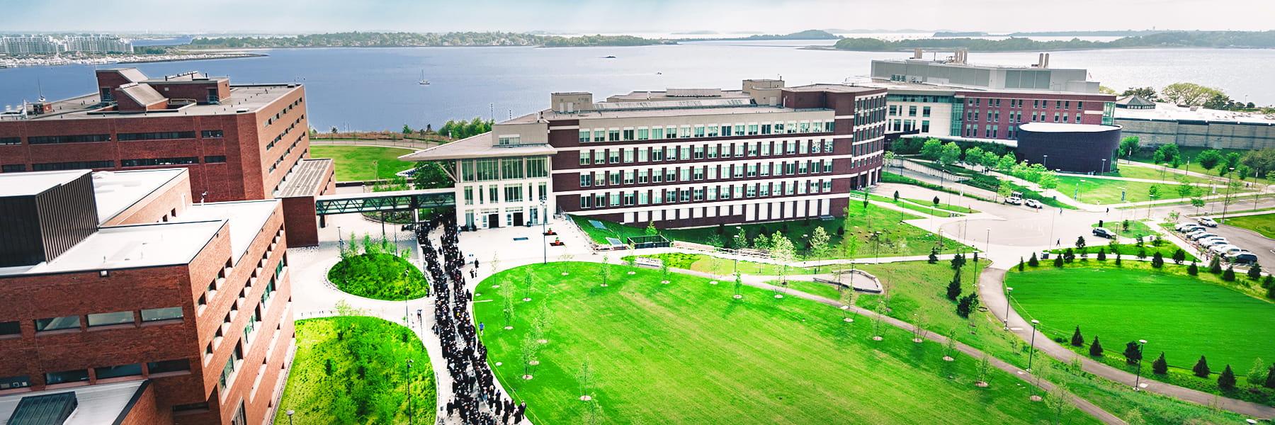 An aerial view of the UMass Boston Quad and the Campus Center with Boston Harbor in the background