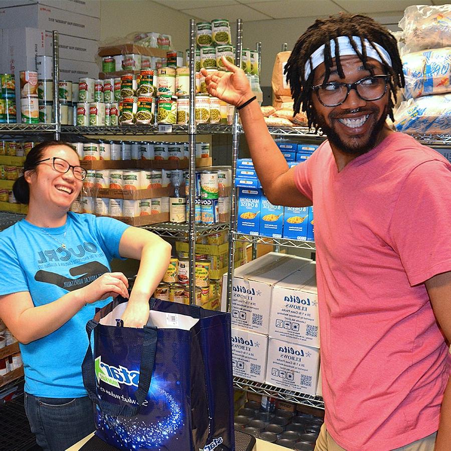 UAccess two students work in supply room with shelves of goods.